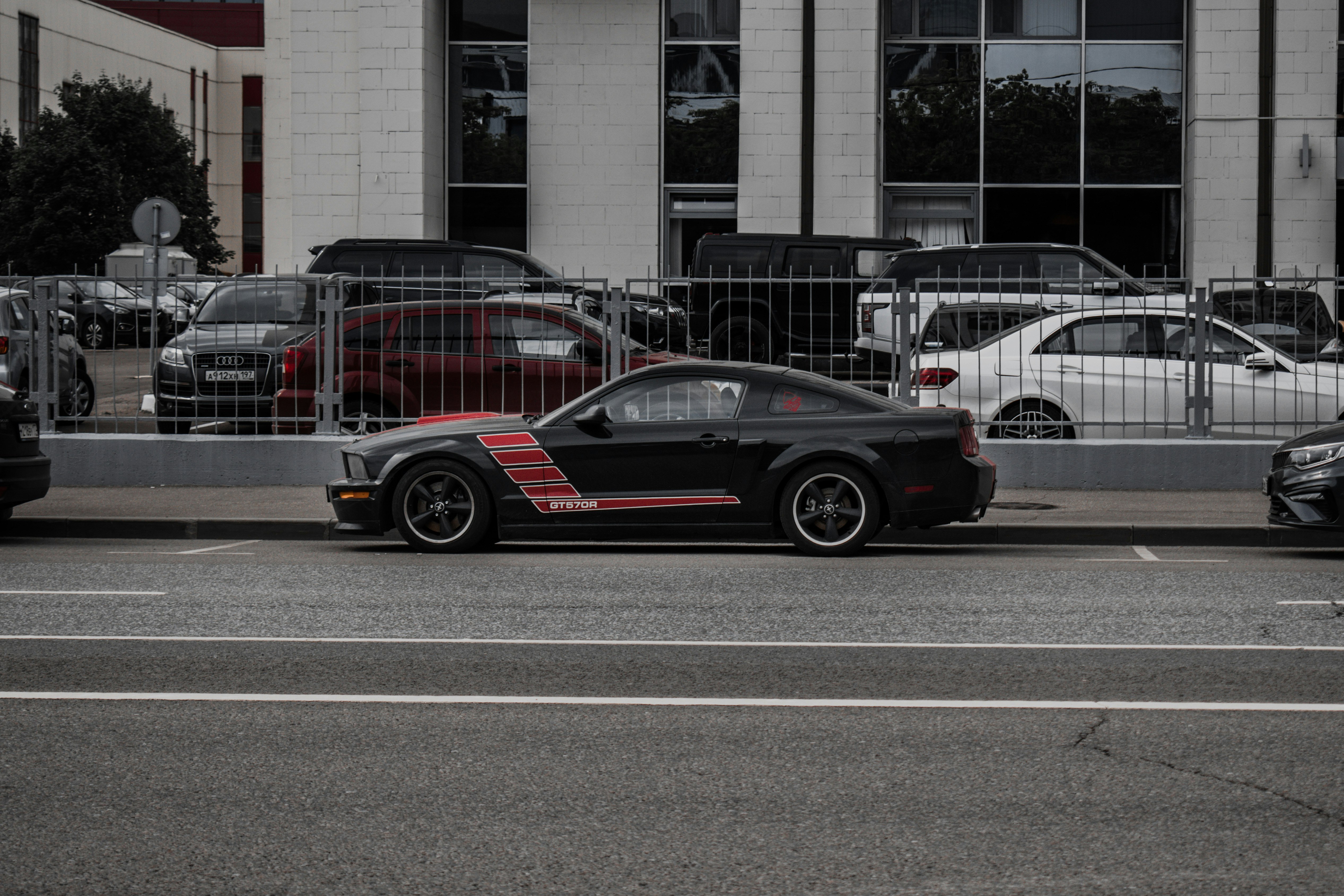 black and red porsche 911 parked on road near building during daytime